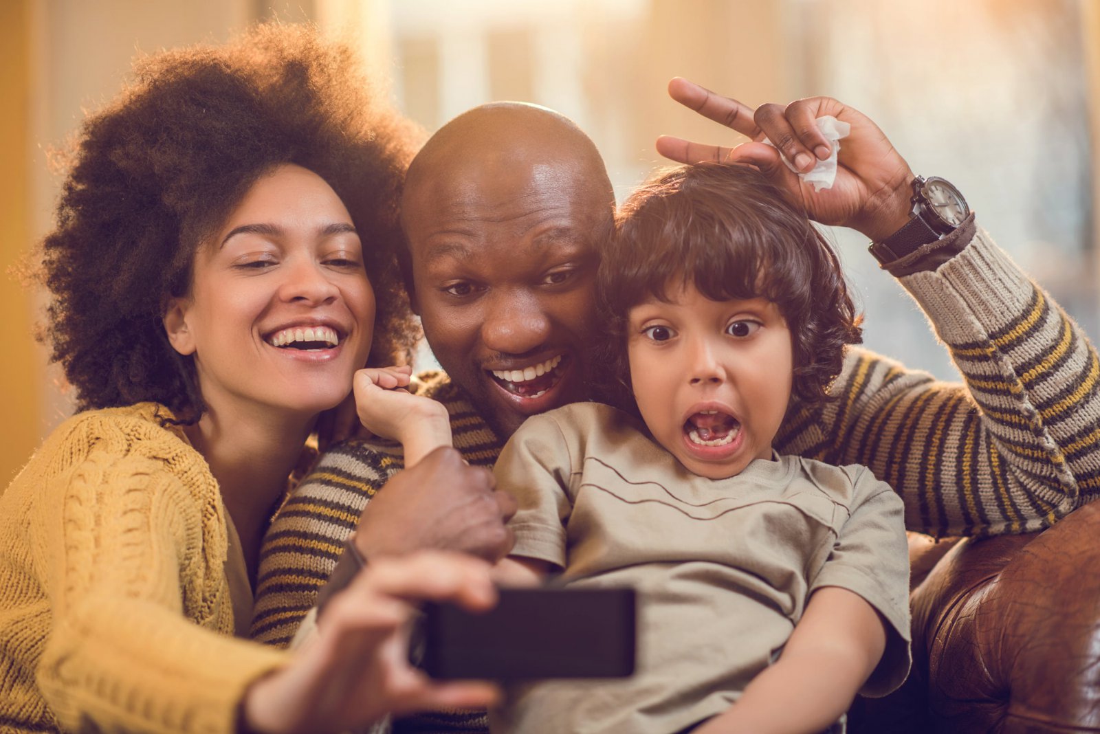 a family of color smiling for a selfie
